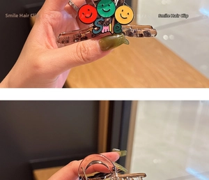 Detail of translucent brown shark clip with colorful smile icons and Smile text art