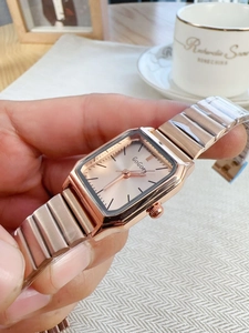 Close-up of a rose gold square dial watch with a stylish metal chain strap for women