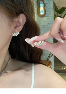 Detail showing the cluster pearl design with gold base on a minimalist earring accessory
