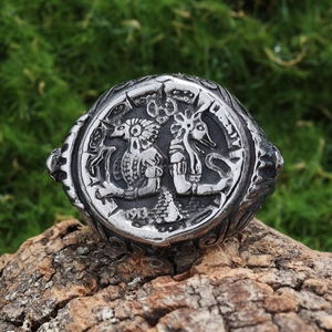 Vintage silver stainless steel ring with embossed Egyptian portrait on a natural wood base