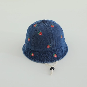 Detail of red strawberry embroidery and white windproof rope on navy denim sun hat