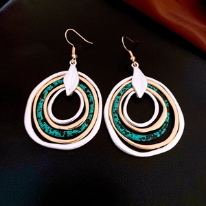 Detail of bohemian multilayer irregular round pendant earrings with turquoise accents