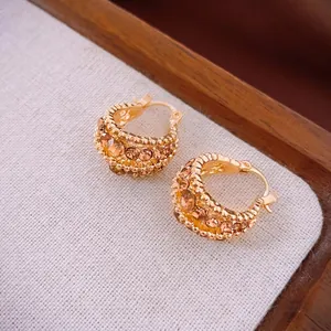 Chic gold hoop earrings with champagne rhinestones and bead edges on linen background