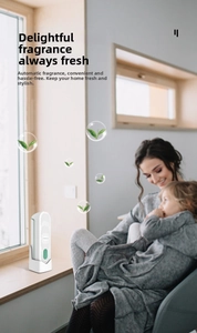 White automatic fragrance diffuser with vertical design on a sunlit window sill