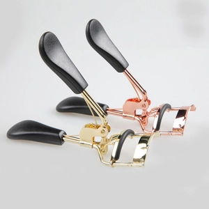 Close-up of portable stainless steel eyelash curler with ergonomic handles and rubber pads