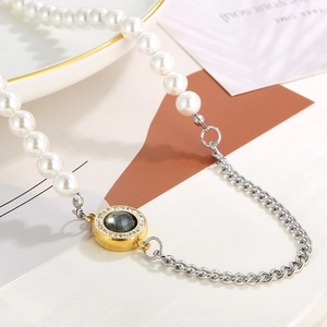 Detail of pearl beads and silver chain link necklace with a gold crystal pendant