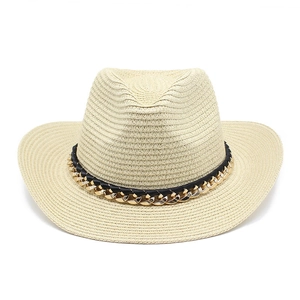 Detalle de sombrero Panamá de paja con cinta negra y decoración de cadena dorada