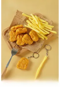 Realistic flexible chicken nugget and french fries keychain on wooden tray and prop paper