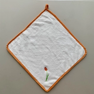 Detail of white coral fleece towel with tulip embroidery and orange hanging loop