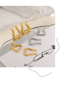 Macro shot of geometric triangular twisted hoop earrings in gold and silver finish