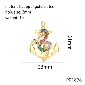 Detailed view of a gold-plated copper anchor pendant with a gemstone-encrusted snake