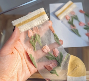 Gros plan de chaussettes en tulle avec broderie de tulipes et détails de rayures