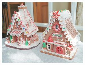 Detailed close-up of light-up gingerbread houses with cream textures and candy accents