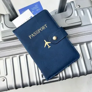 Detail of navy blue PU leather passport holder with gold airplane logo on luggage