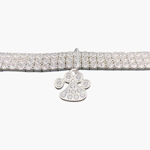 Close-up of triple-row rhinestone pet collar with a sparkling silver paw print pendant