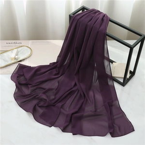 Detailed texture of plum purple chiffon scarf draped elegantly on a modern metal rack