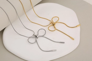 Detailed macro shot of gold and silver bow necklaces with premium snake chain textures