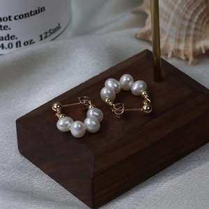 Eleganti orecchini di perle d'acqua dolce su base in legno e sfondo in seta raffinata