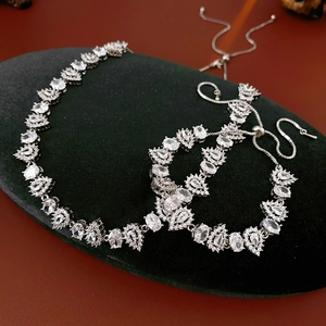 Detailed view of silver zircon drop necklace and adjustable bracelet on velvet display
