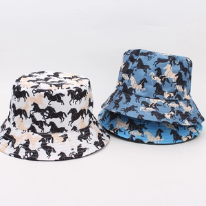 Detail view of double-sided bucket hats in white and blue with horse prints