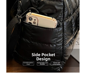 Detail of black quilted puffer bag side pocket with smartphone for size reference