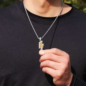 Close-up of hip hop lightning pendant with bicolor cubic zirconia on silver rope chain