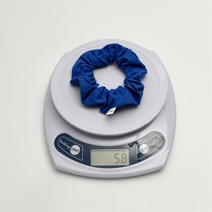 Detailed view of dark blue cotton scrunchie on electronic scale showing 5.8g weight