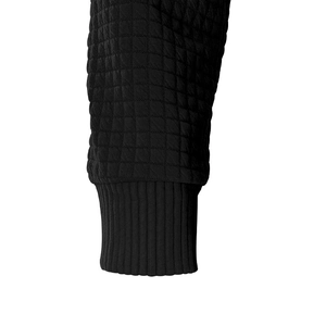 Detail shot of black quilted fabric with elastic ribbed cuffs on hooded sweatshirt