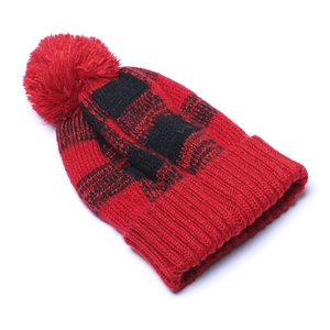 Detail of red and black buffalo plaid knit beanie with a large matching pompom