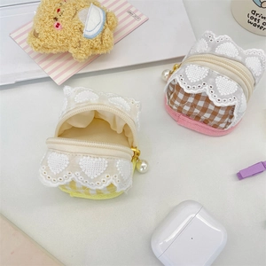 Detail of plaid earbud pouch with lace trim and pearl zipper pull in a cute setup