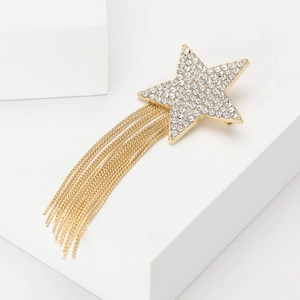 Elegant star brooch with sparkling rhinestones and golden tassels on white geometric props