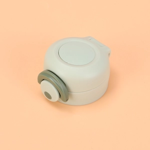 Detailed view of a light green vacuum flask lid with a secure dark green locking latch