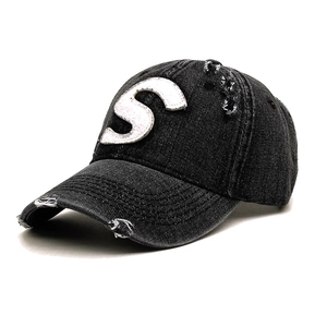 Detailed close-up of distressed denim baseball cap with vintage white S letter embroidery
