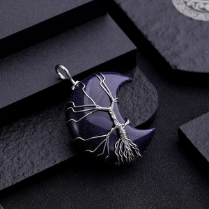 Detail of blue aventurine moon pendant with silver wire-wrapped tree of life design