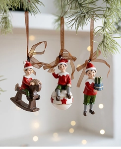 Detailed view of resin Christmas elf ornaments with gift box and rocking horse features