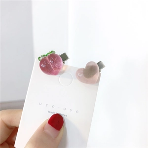 Close-up of pink peach and heart shaped hair clips on a white display card