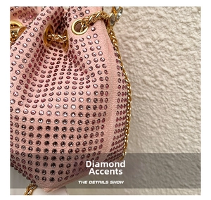 Close-up of pink rhinestones and gold chain detail on the luxury bucket handbag