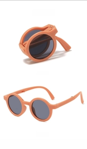 Detailed view of orange foldable round children's sunglasses with UV protection lenses