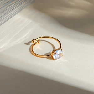 Macro detail of 18k gold plated ring with oval clear zircon and elegant light shadow effects