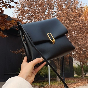 Sac bandoulière tendance en cuir PU noir avec boucle dorée sur fond de feuilles d'automne