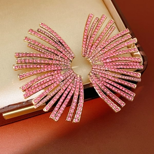 Detail of pink zircon fan-shaped earrings with rose gold base on satin background