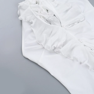 Detailed view of ruffled edges and delicate white pearl embellishments on the neckline
