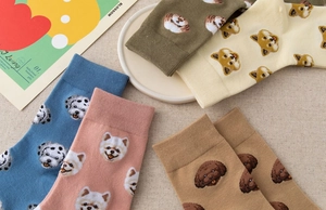Detail of colorful cotton crew socks featuring various cute dog patterns and ribbed cuffs