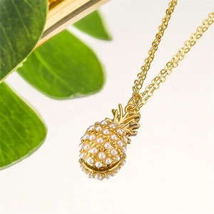 Macro shot of gold pineapple pendant necklace featuring intricate white pearl inlay details