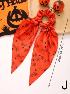 Detail of Halloween hair scrunchie with long ribbons featuring orange ghost and spider web prints