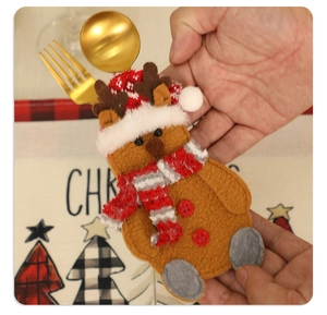 Close-up of reindeer felt cutlery holder with golden spoon and fork for Christmas table decor