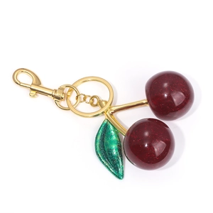 Close-up of cherry keychain with sparkling resin fruits, green leaf and gold carabiner