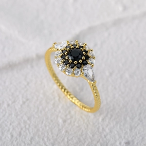 Detailed macro view of vintage gold ring with black gemstone cluster and crystal borders