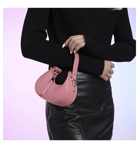 Close-up of pink lychee grain leather crescent bag with golden hardware detail