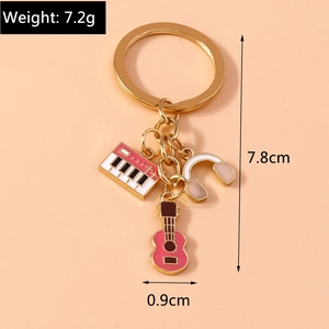 Detail view of musical charms keychain with pink guitar, piano keys, and white headset